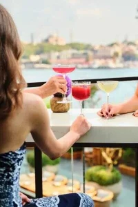 The Peninsula Istanbul Topside Bar’da İstanbul manzarasına karşı yaz akşamı.